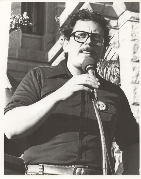 black and white photo of José Angel Gutiérrez speaking at a police brutality protest